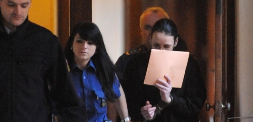 Obviněná žena si zakrývala při příchodu k soudu tvář.