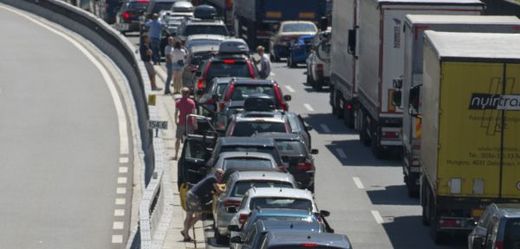 Lidé postávají vedle aut v zácpě na rakouské dálnici (ilustrační foto).
