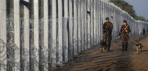 Maďarští vojáci hlídkují u plotu na hranici se Srbskem.