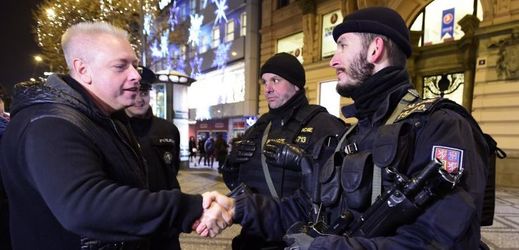 Ministr vnitra  Milan Chovanec (ČSSD) se zdraví s policisty v ulicích Prahy.