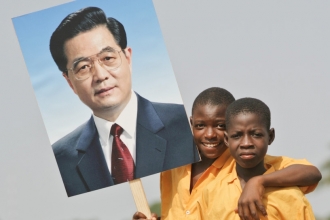 Malí Afričané s transparenty nejvyšších čínských státníků.