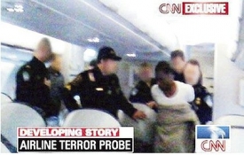 Policie odvádí z paluby letadla nigerijského teroristu.