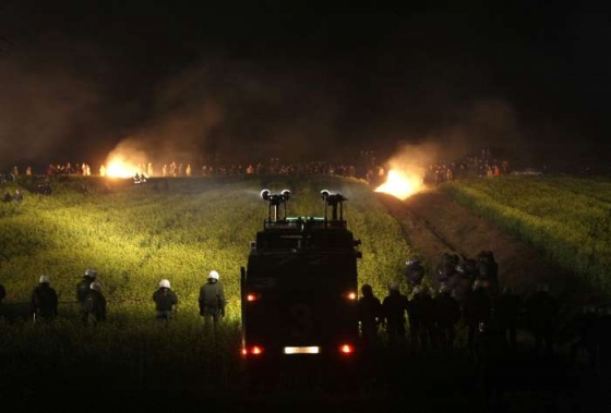Krajinu před bitvou osvětlují hořící balíky slámy zapálené aktivisty.