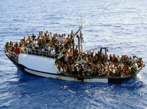 Uprchlíci překonávají Středozemní moře v přecpaných bárkách.