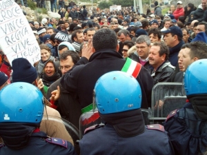 Starosta města mluví k protestnímu shromáždění občanů Lampedusy.