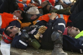 Vyčerpaní záchranáři podílející se na likvidaci následků zemětřesení.