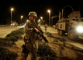 Američtí vojáci odstraňují bombu u silnice do Mosulu.
