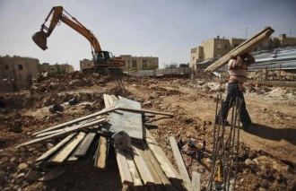 Palestinští dělníci stavějí Izraeli nové sídliště u vých. Jeruzaléma.