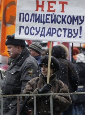 Žena drží transparent s nápisem: Ne policejnímu státu.