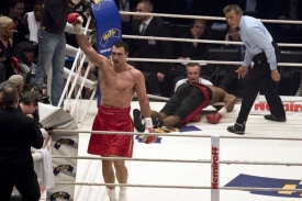 Vladimir Kličko je boxerská mašina. V pozadí knokautovaný soupeř.