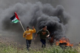 Mladí Palestinci prchají před izraelskými vojáky při nepokojích.