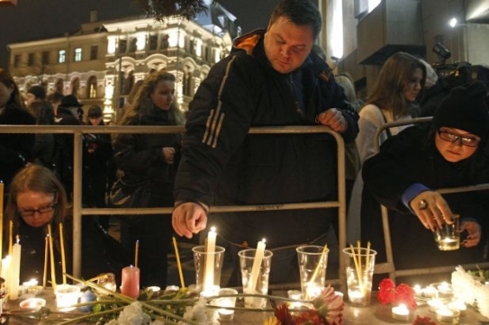 Lidé zapalují svíčky jako vzpomínku na oběti útoku.