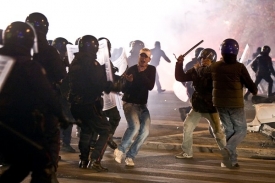 Pobodaný fotbalový fanoušek před kordonem policistů.
