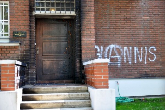 Oheň poškodil vstupní dveře, na fasádě přibyl nápis se jménem Giannis.