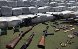 Balíky marihuany a zbraně zabavené drogovým bandám v Mexiku.