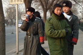 Zástupci čínských bezpečnostních složek hlídkují při demonstraci.