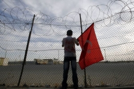 Chlapec s tureckou vlajkou čeká na jednoho z vyhoštěných z Izraele.