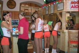 V Hooters vás obslouží dívky v oranžových kraťasech a bílém tílku.