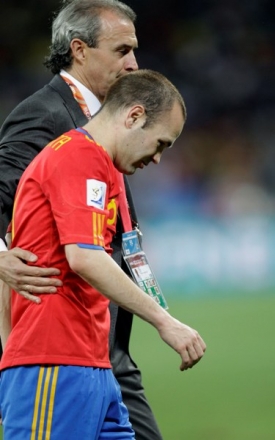 Zklamaný záložník Španělska Andrés Iniesta s asistentem trenéra.