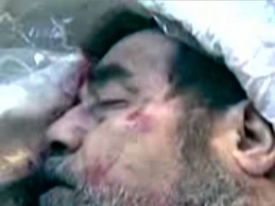 Snímek z mobilního telefonu ukazující tělo Husajna po popravě.