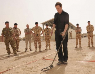 Britský premiér Cameron s minohledačkou u vojáků v Hílmandu.