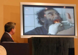 US ambasador Bremer předvádí video s lapeným Saddámem.