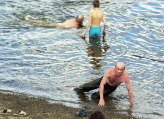 Opilci se zchlazují v řece Moskvě.
