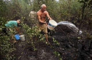 Ruští občané hasí svépomocí hořící les.