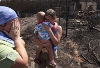 Zoufalí lidé u spálených domovů ve vesnici Mochovoje 135 km od Moskvy.