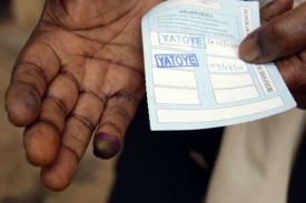 Hlasovací lístek a po hlasování začerněný prst.