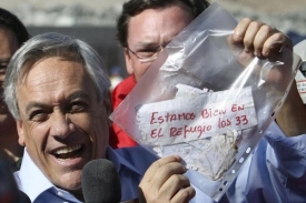 Prezident Sebastián Piňera ukazuje novinářům vzkaz od horníků.