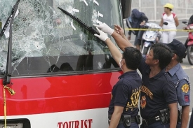 Policisté prohlížejí po neúspěšném zásahu prostřílený autobus.