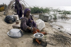Žena připravuje jídlo v provizorním tábořišti.