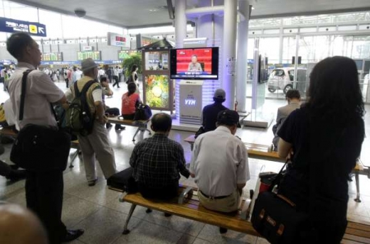 Jihokorejci sledují na nádraží severokorejského vůdce v TV.