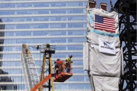 Dělníci zvedají trojzubec, součást památníku 11. září. 