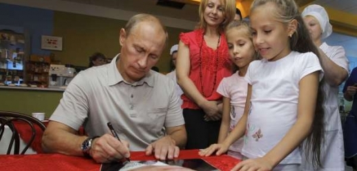 Putin podepisuje dětem svůj plakát.