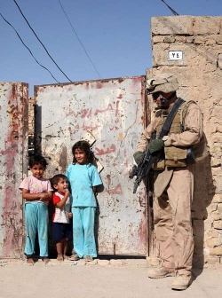 Americký voják s iráckými dětmi ve středním Iráku roku 2004.