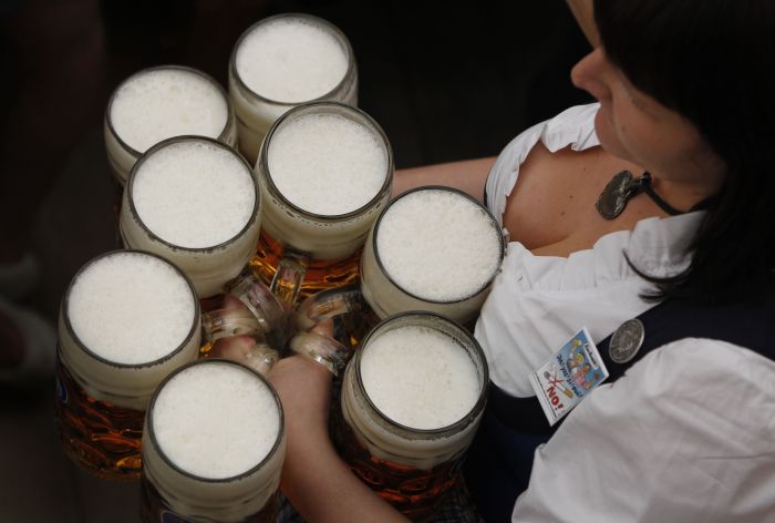 Servírka,  která má na kroji připnutý odznak s nekuřáckým logem, roznáší pivo. Letošní Oktoberfest je poprvé nekuřácký. (Foto: ČTK/AP) 