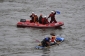 Loď závodníků vypadá, že se každou chvíli potopí, záchranáři se ujišťují, že posádka svízelnou situaci zvládne.