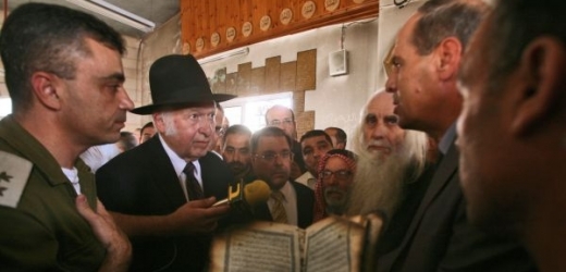 Rabíni si prohlížejí jeden z ohořelých koránů.