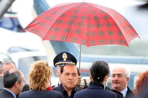 Berlusconi na letišti v doprovodu sličných dívek. Tak podle fotografa začala práce na fotkách z premiérovy vily.