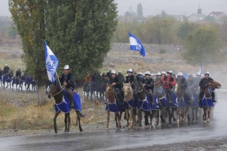 Kyrgyzští jezdci jedou na volební shromáždění.