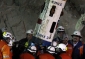 Horníka Jimmyho Sanchéze (uprostřed) vítají, když vystoupil z kapsule Fénix, která ho bezpečně dopravila na zemský povrch.