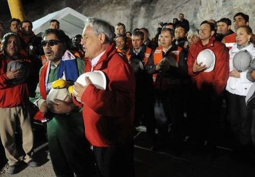 Chilský prezident a vyproštění horníci zpívají národní hymnu.