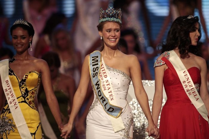 Američanka Alexandria Millsová (uprostřed) se drží za ruce s botswanskou miss Emmou Wareusovou (vlevo) a venezuelskou miss Adrianou Vasiniovou (vpravo) poté, co vyhrála titul.