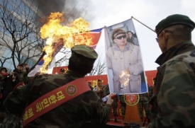 Demonstranti pálí portrét severokorejského vůdce Kim Čong-ila. 