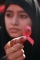 Vysokoškolská studentka ukazuje červenou stuhou, symbol pro povědomí o AIDS, v Jammu v Indii. (Foto: ČTK/AP)