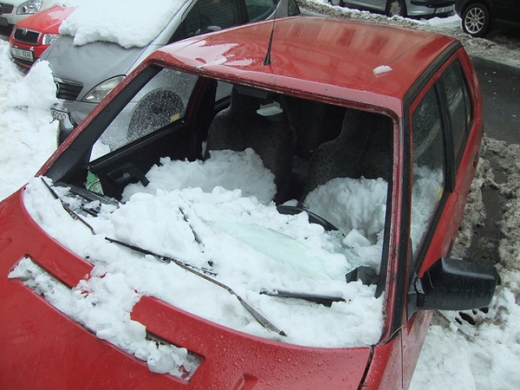 Auto zdemolované spadlým sněhem v pražské Hálově ulici. (Foto: Daniel Poláček)