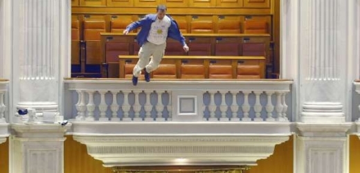 Výraz zoufalství. Pracovník rumunské televize padá z balkonu v parlamentu.