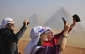 Venezuelští turisté pozorují astronomický jev před pyramidami v egyptské Gíze.